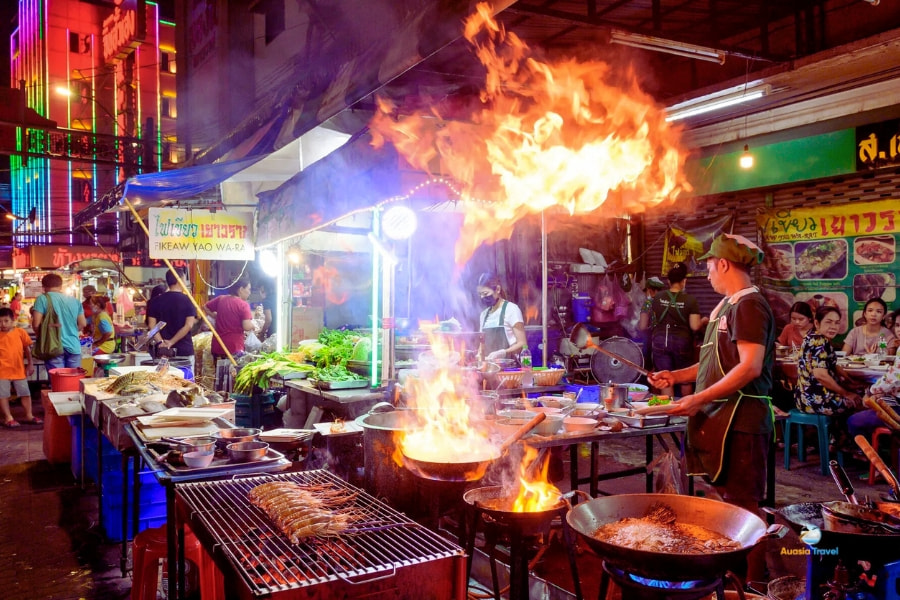 Bangkok street food night market with chef cooking flames – Auasia Travel